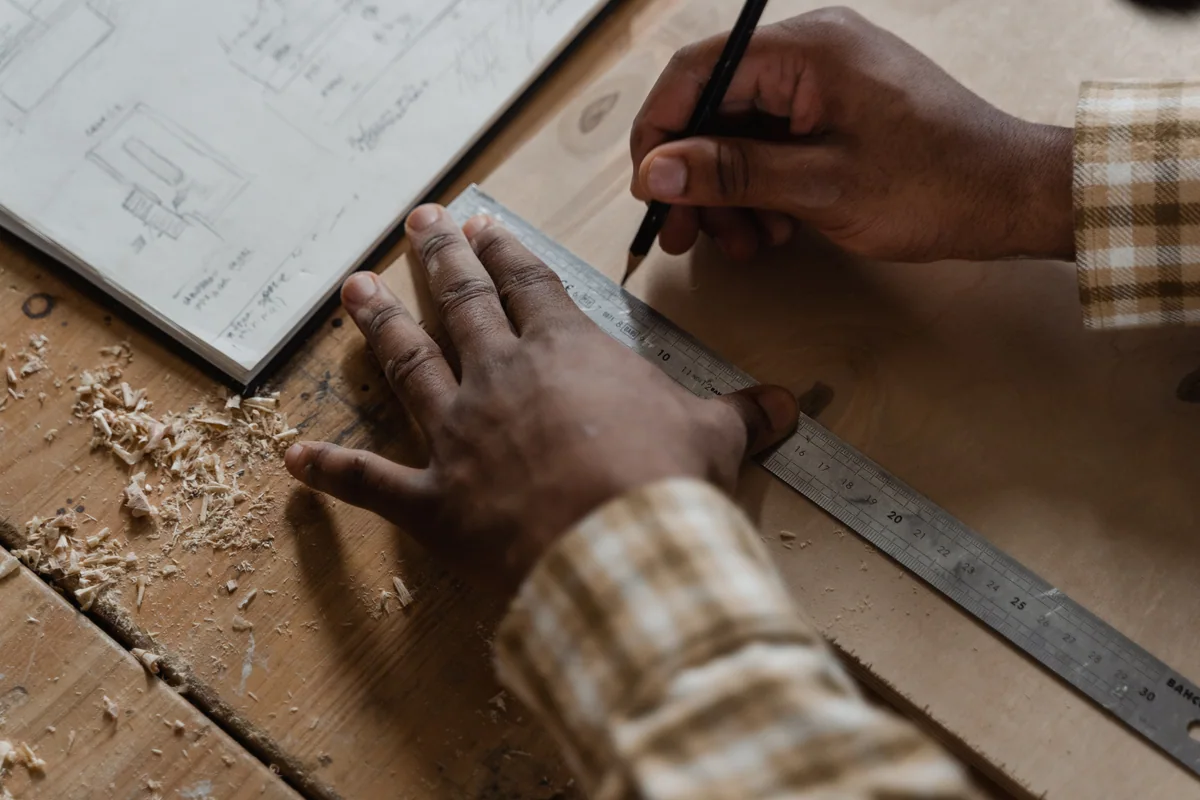 Craftsperson carefully marking material for a custom installation