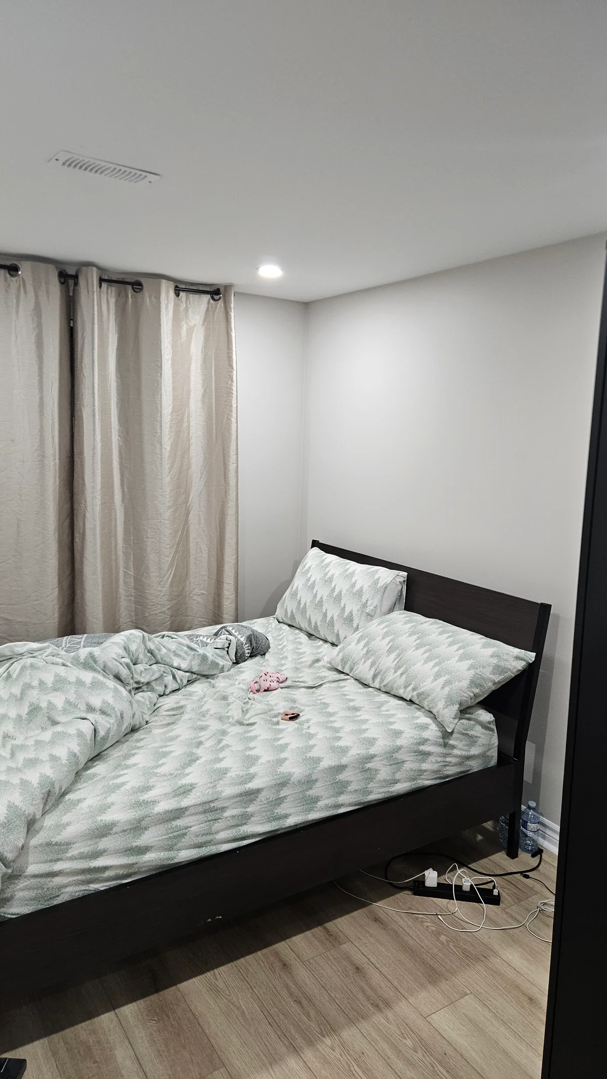 Finished basement bedroom with grey walls and light wood-look flooring