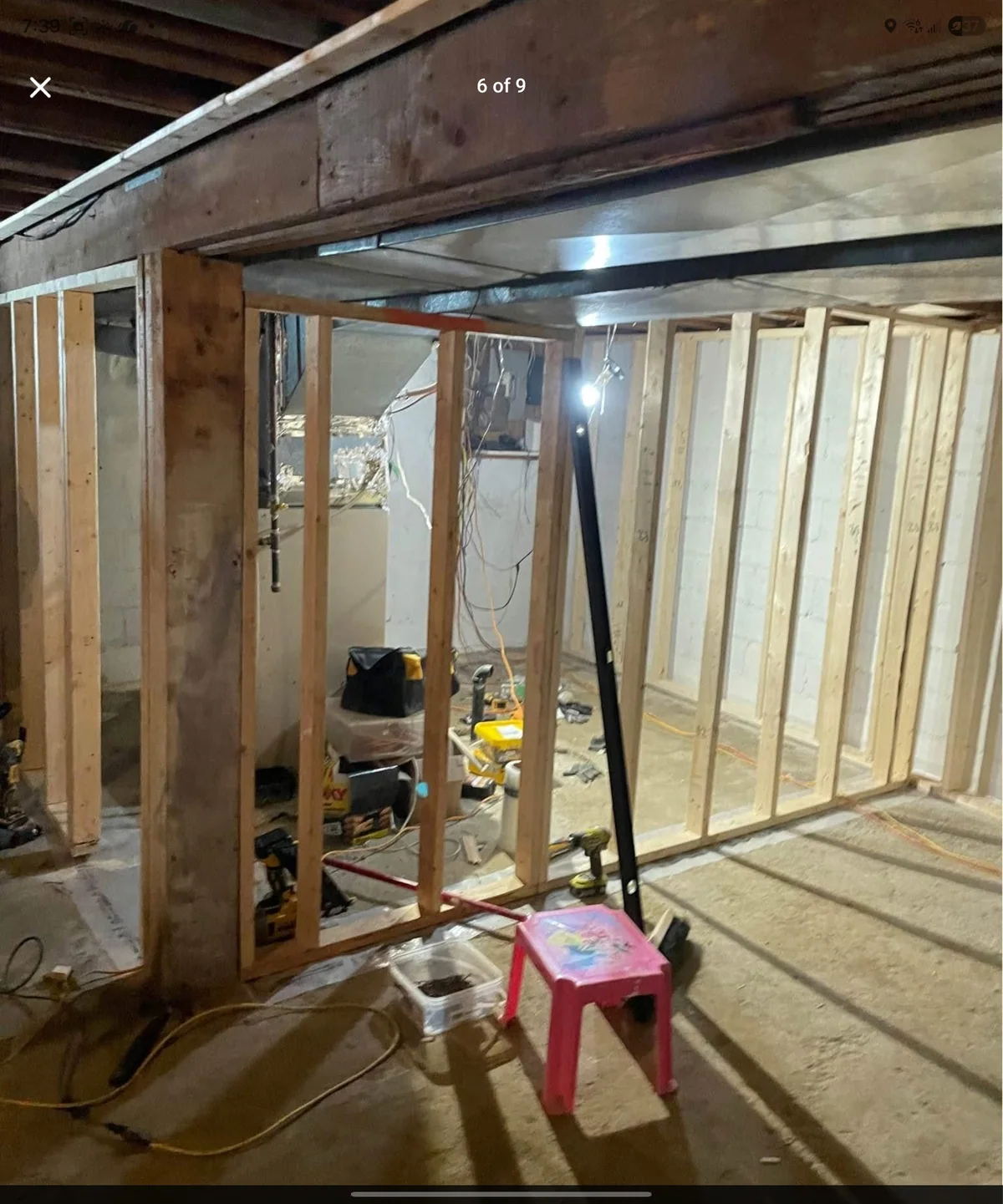 Basement wall framing in progress around a utility area