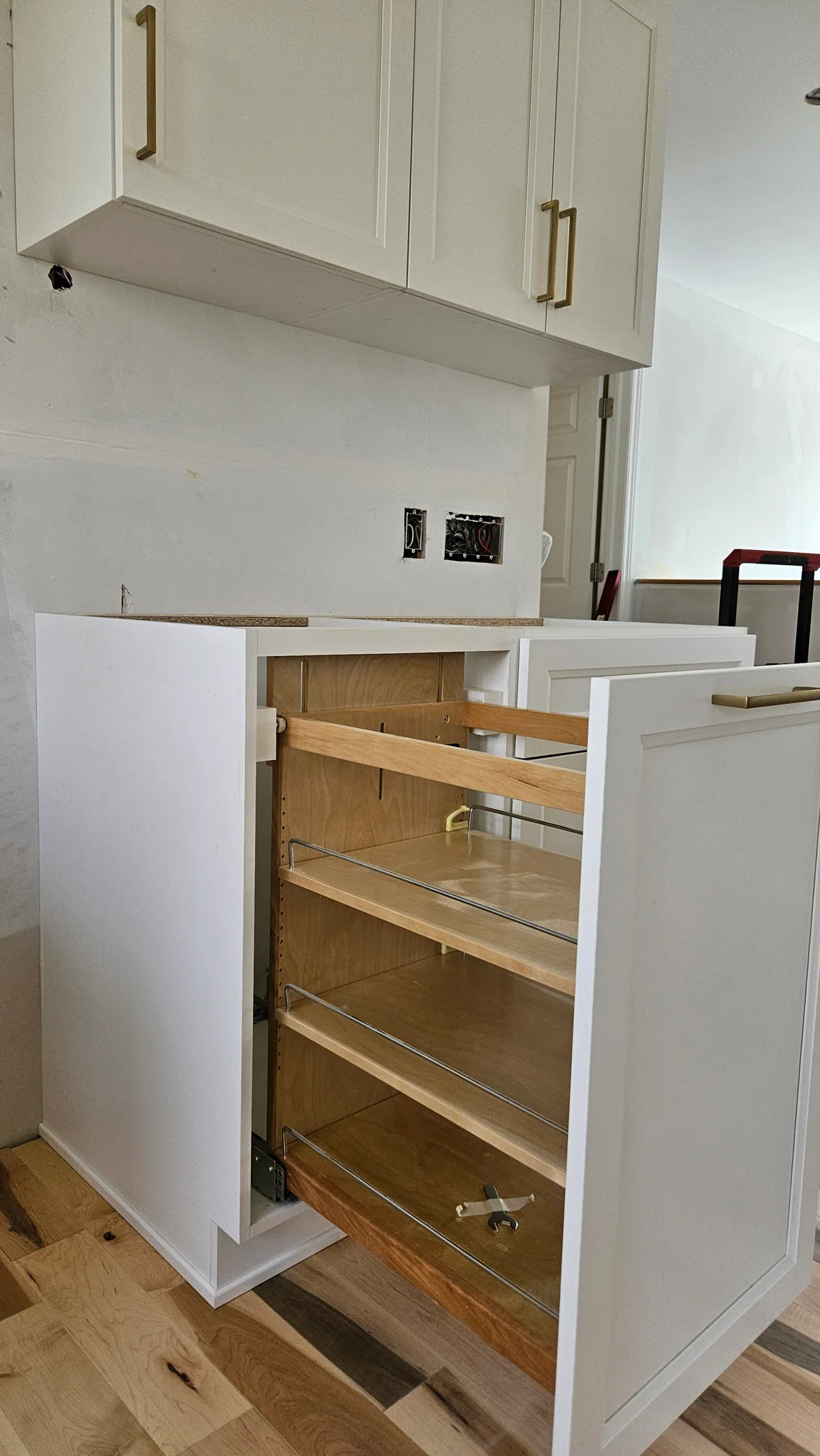 Open pull-out wood pantry storage integrated into white cabinetry